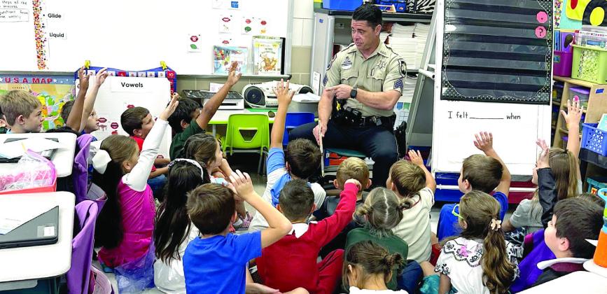 Sgt. Brian Canepa, SBSO recruiter, chats with Joseph Davis Elementary School students after he read a couple books to them during Literacy Week.