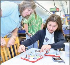 Our Lady of Prompt Succor teacher Kathy Scheuermann watches as sixth grader Addisyn Amadeo works on STREAM activities.